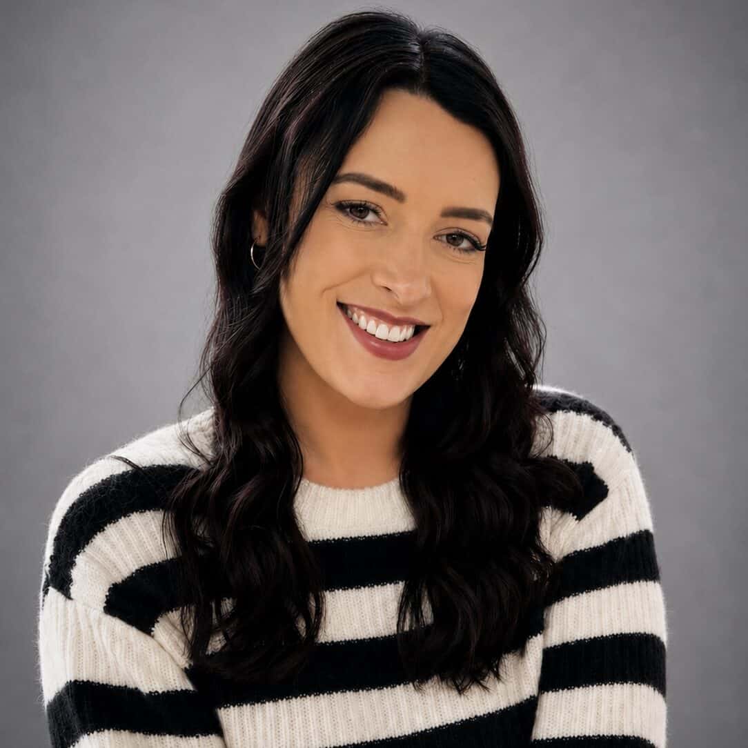 Kim photo Smiling woman with dark hair in a striped sweater against a grey background.