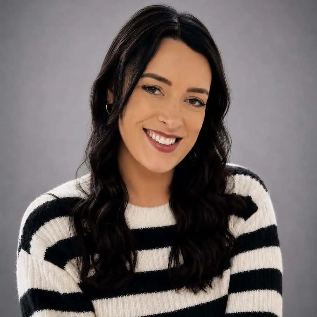 Kim photo Smiling woman with dark hair in a striped sweater against a grey background.