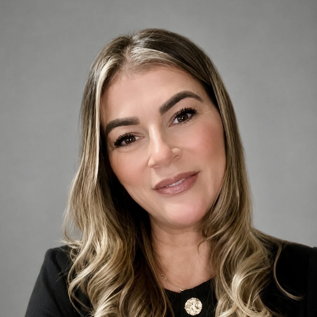Sherridon Photo Portrait of Laura Cardy, smiling woman with long wavy hair and makeup.