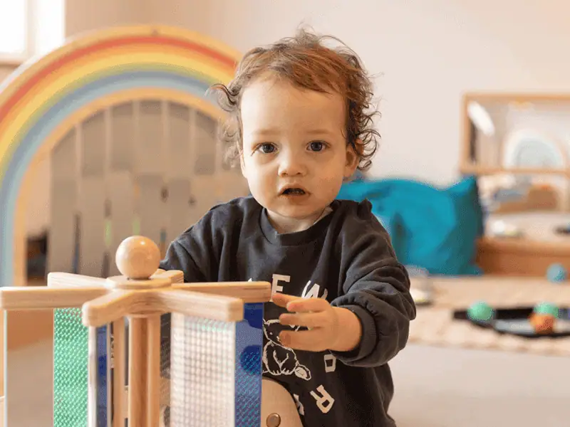 Monkey Puzzle Day Nursery Altrincham Child Young child playing with wooden toys at Monkey Puzzle Day Nursery Altrincham.